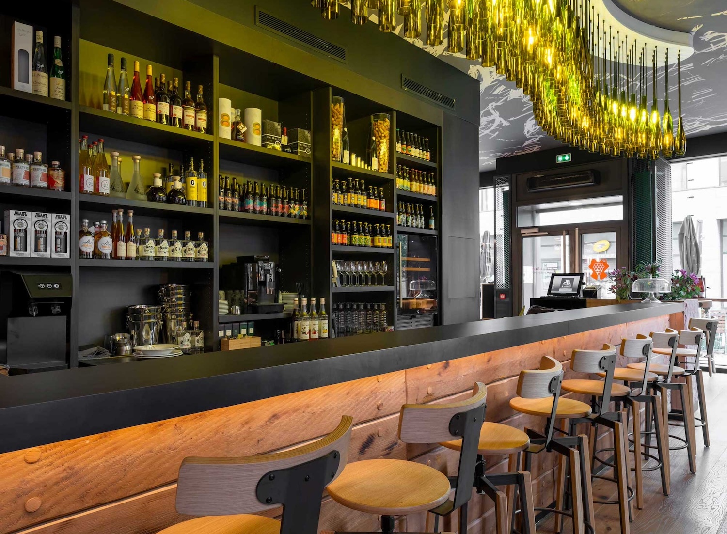 Bar moderne avec étagères de bouteilles et tabourets en bois